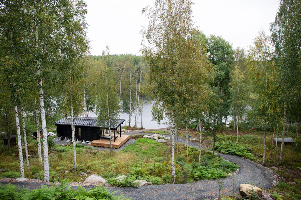 Moderni Pluspuu Airisto hirsihuvila rinteessä kalliolla ja järvenrannalla
