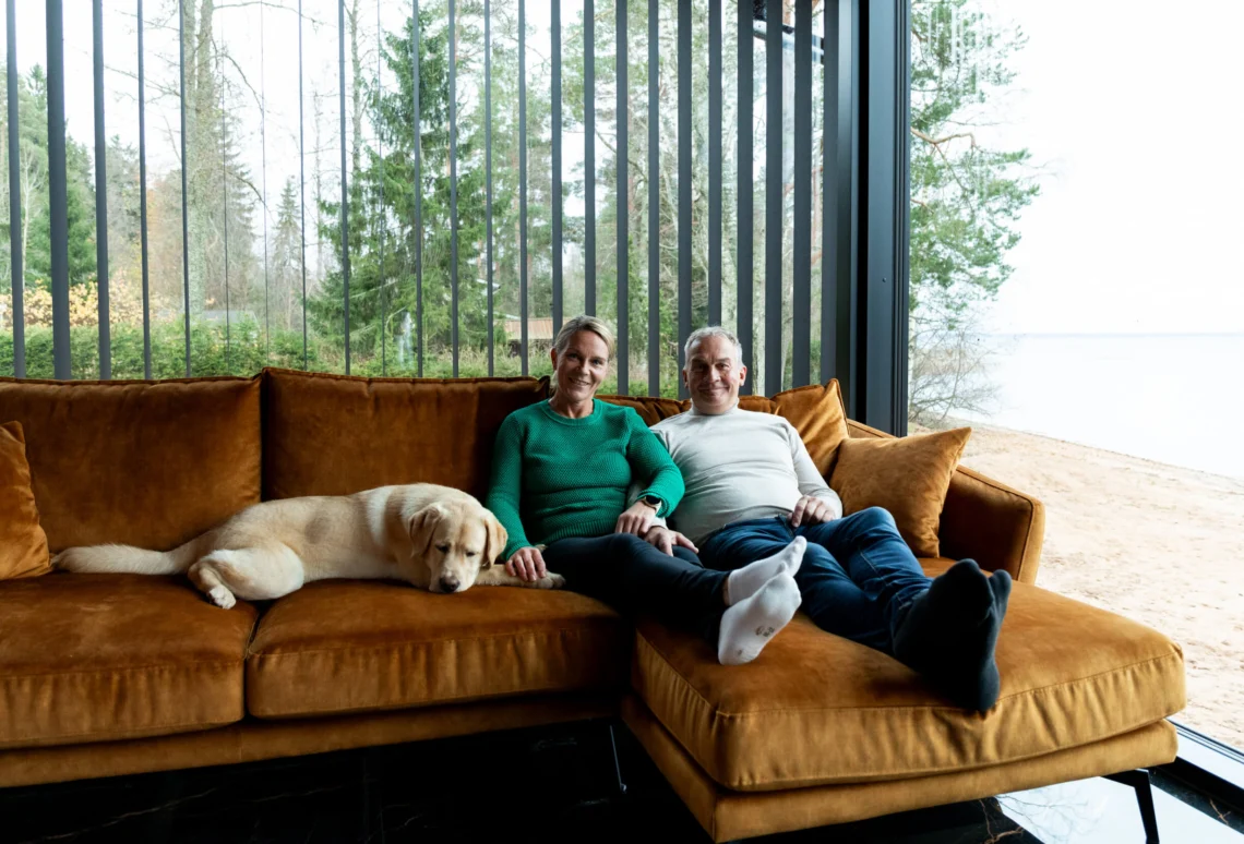 Pariskunta rentoutuu hirsitalon sohvalla