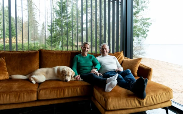 Pariskunta rentoutuu hirsitalon sohvalla